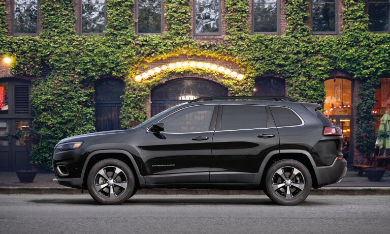 2023 Jeep Cherokee side parked by ivy-covered building